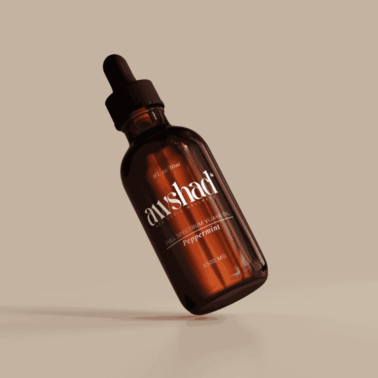 Brown glass bottle with dropper labeled 'awshad' on a beige background