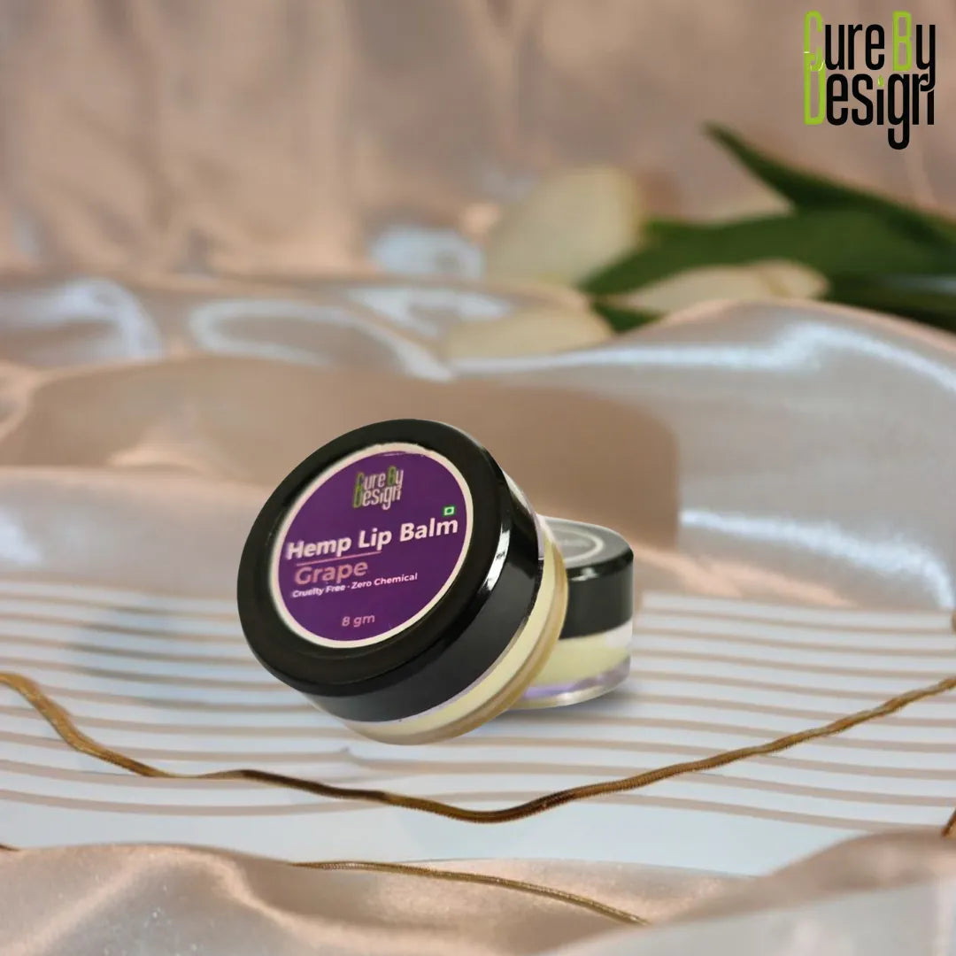 Hemp lip balm with purple label on a decorative surface, featuring 'Pure by Design' branding.