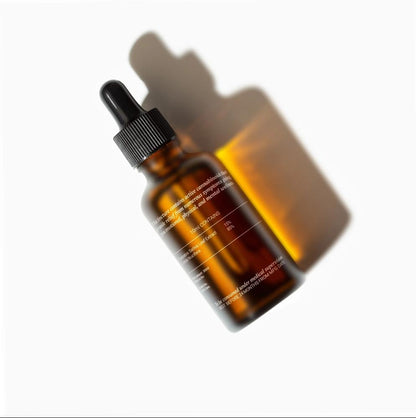 Amber glass dropper CBD Oil bottle with shadow on a white background.