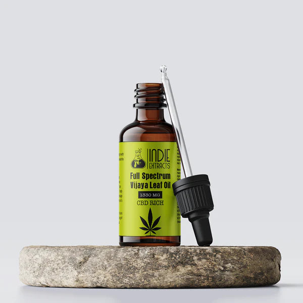CBD oil bottle with dropper on a stone surface against a light gray background