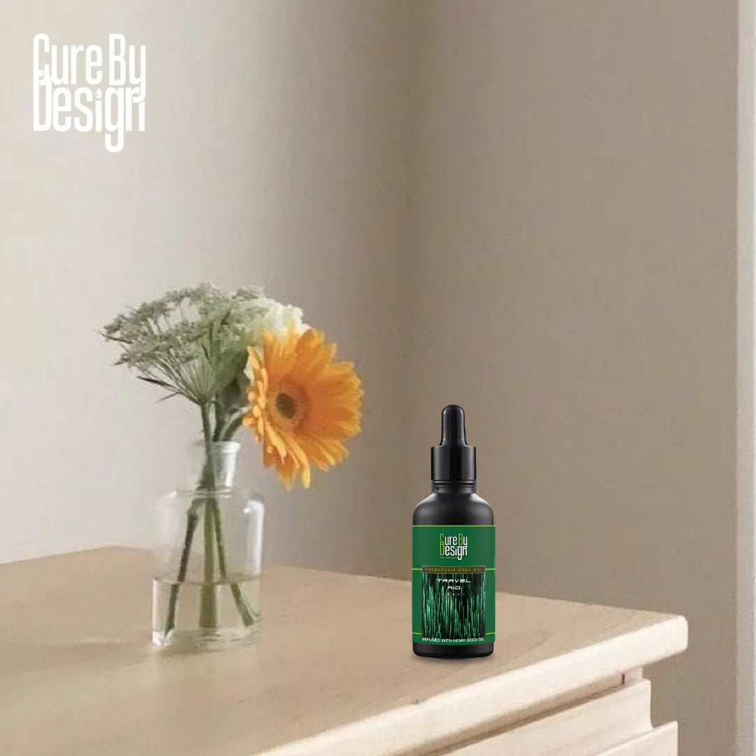 Bottle of Cure By Design product on a surface with flowers in the background