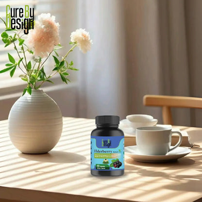 Bottle of Elderberries supplement on a table with a vase of flowers and a cup in the background.