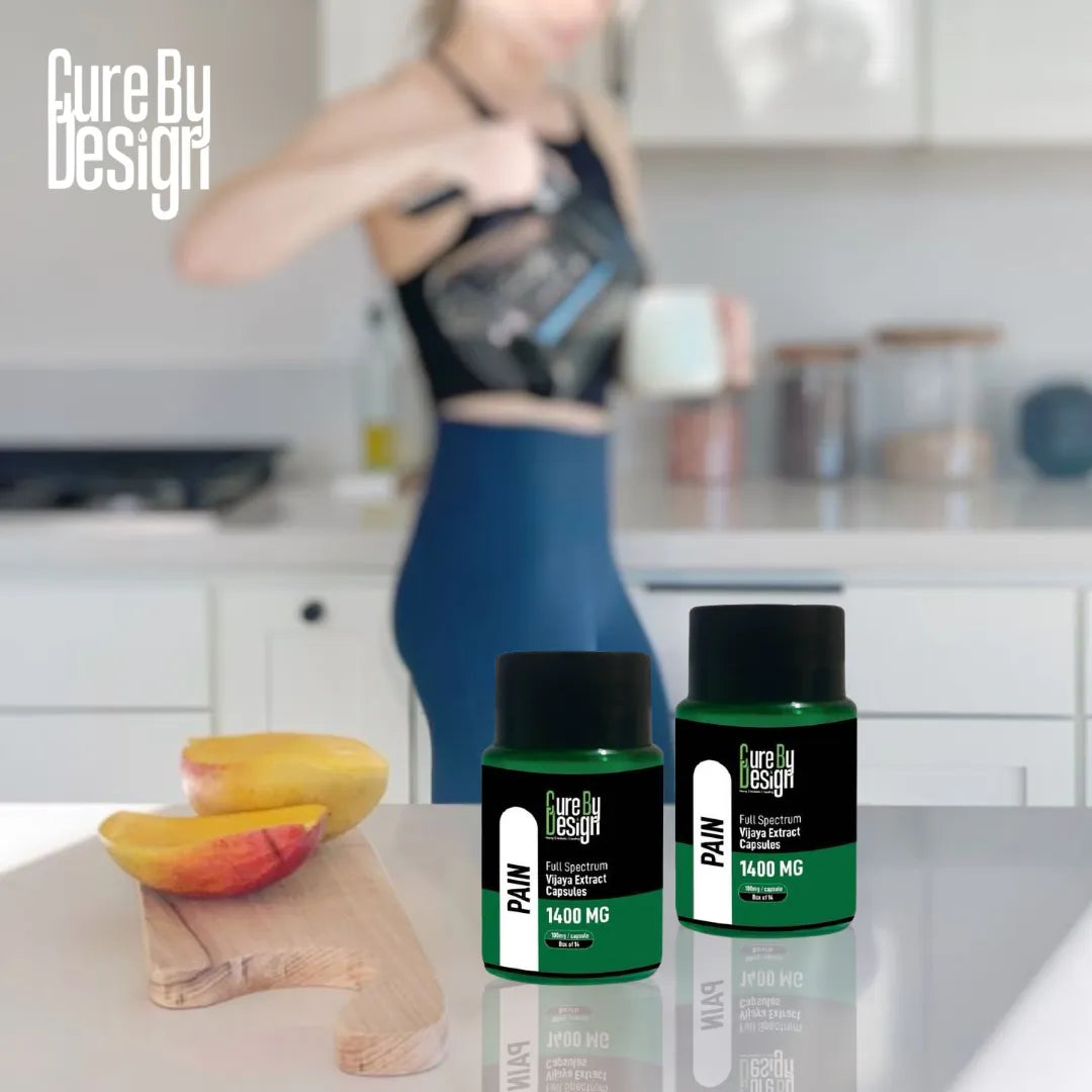 Two bottles of 'Cure By Design' Pain Relief Vjaya Extract capsuels supplement on a kitchen counter with a blurred person in the background.