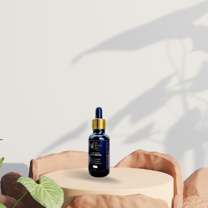 Alt-Text: Gold-capped blue dropper bottle on a beige pedestal, surrounded by rocks and a plant.

