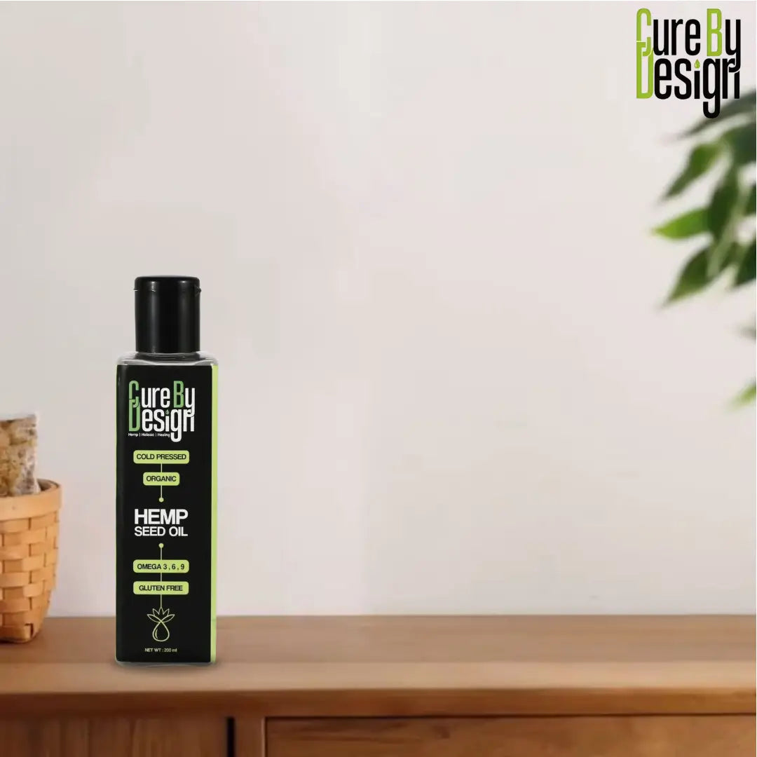 Bottle of Hemp Seed Oil by Cure By Design on a wooden surface with a white background