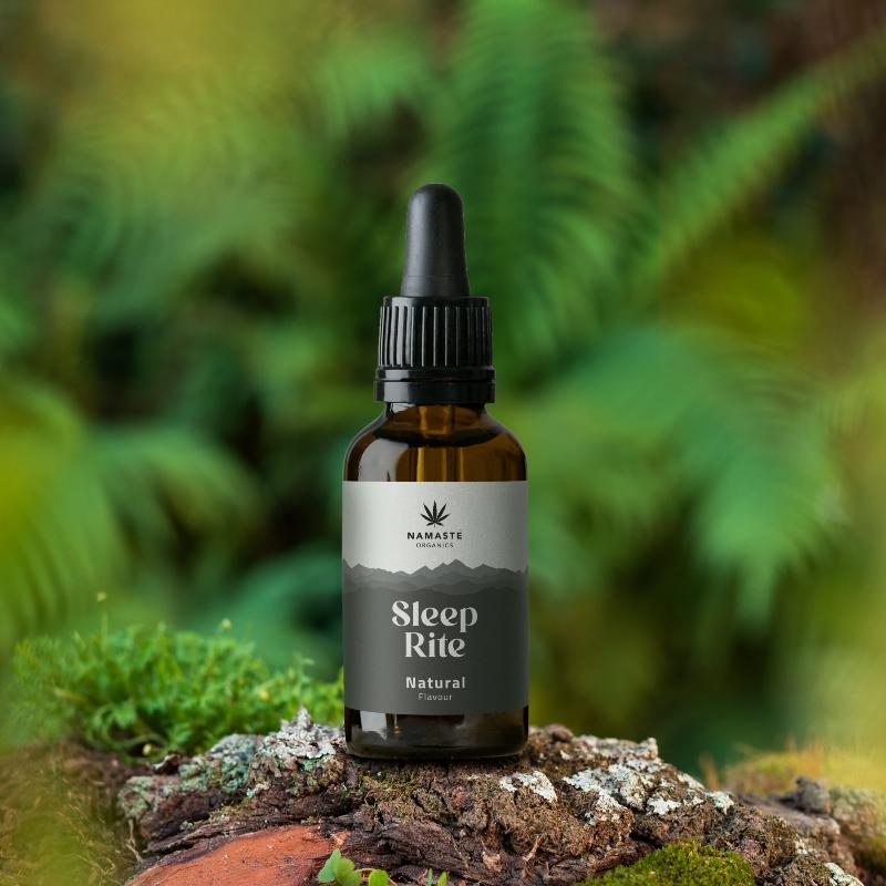 Bottle of Namaste Naturals Sleep Rite on a natural background with greenery.