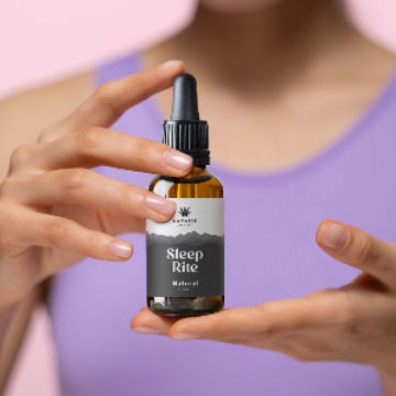 Bottle labeled 'Sleep Rite' Full spectrum CBD Oil held by a person against a pink background