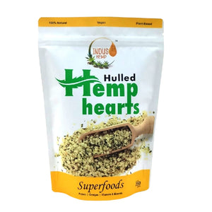 Package of hulled hemp hearts with a wooden scoop on a white background