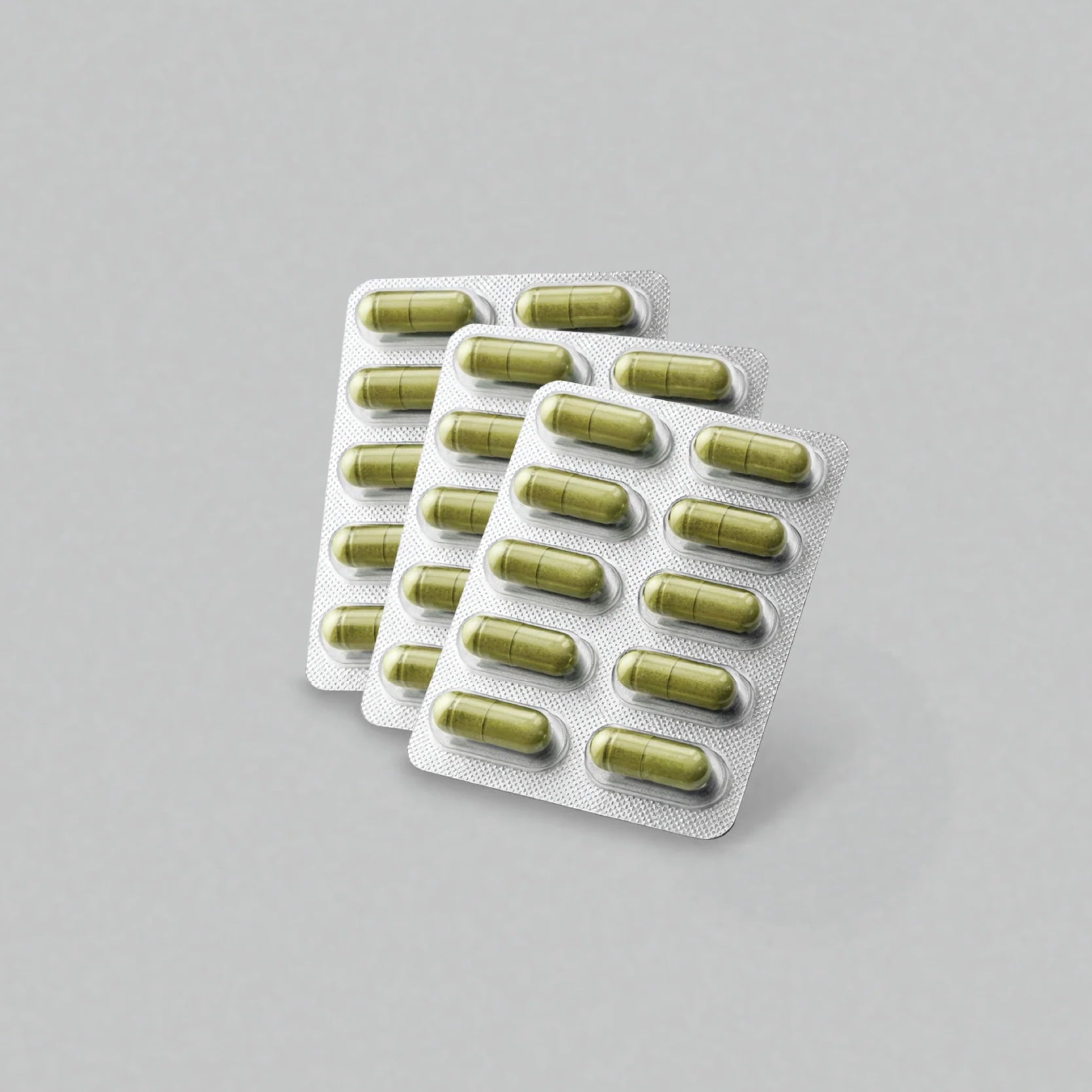Multiple packs of green vijaya capsules on a gray background