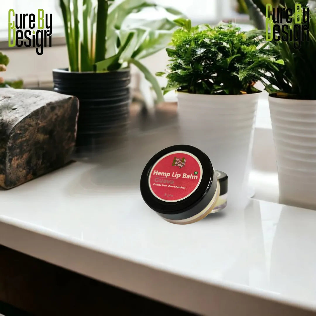 Hemp lip balm on a white surface with plants in the background
