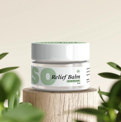Jar of Awshad "INTENSO CBD Relief Balm" on a wooden stump with plant leaves in background.
